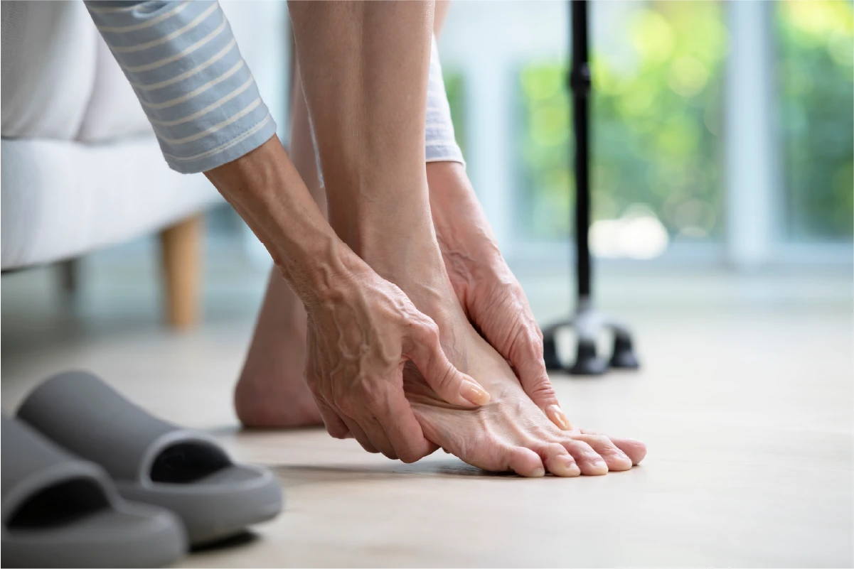 Person massaging a painful foot and ankle at the end of the day.