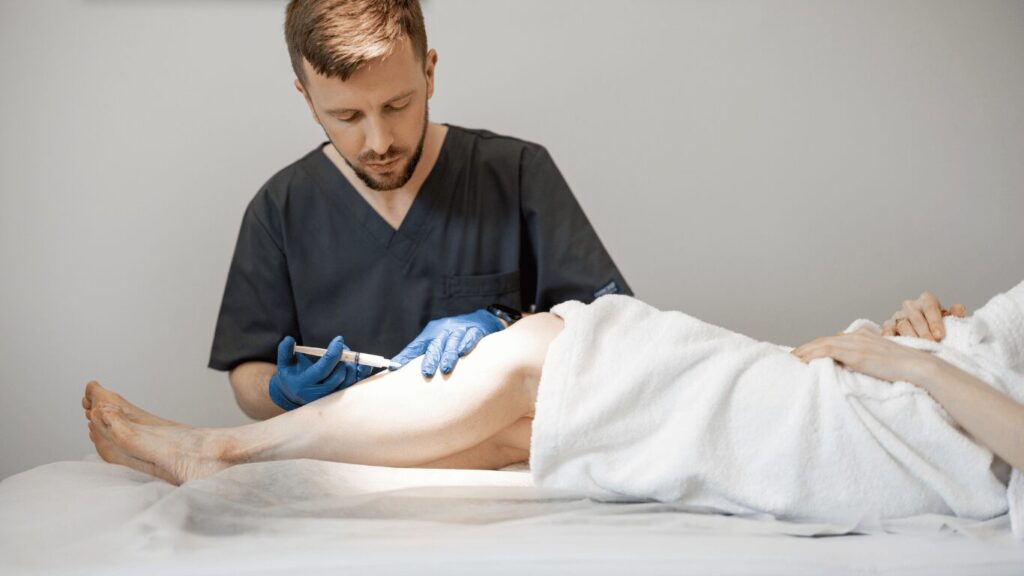 323 Phlebologist performing sclerotherapy treatment.